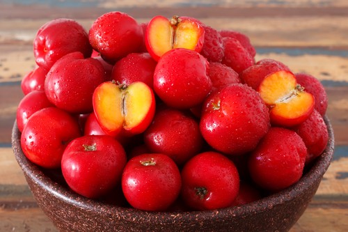 Red acerola - malpighia glabra, tropical fruit  in wicker busket